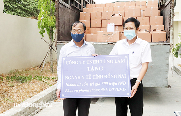 Đại diện Công ty TNHH MTV Tùng Lâm trao bảng tượng trưng 10 ngàn lít cồn cho ngành Y tế Đồng Nai   Ảnh: Hạnh Dung