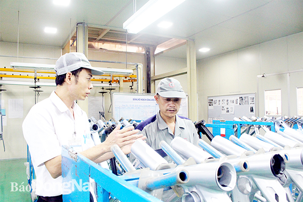 Đại diện Công đoàn cơ sở Công ty hữu hạn Cơ khí động lực Toàn Cầu (H.Trảng Bom, bên trái) thăm hỏi công nhân tại xưởng làm việc