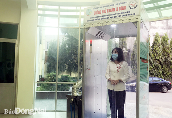 Bà Nguyễn Thị Hoàng, Giám đốc Sở KH-CN trải nghiệm sử dụng buồng khử khuẩn di động do các cán bộ, viên chức Trung tâm KH-CN thực hiện. Ảnh: H.Yến