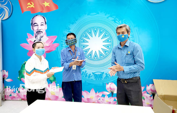Phó chủ tịch Liên đoàn Lao động tỉnh Hồ Thanh Hồng (bìa phải) tặng quà cho đoàn viên khó khăn bị ảnh hưởng  thu nhập, công việc do dịch bệnh Covid-19