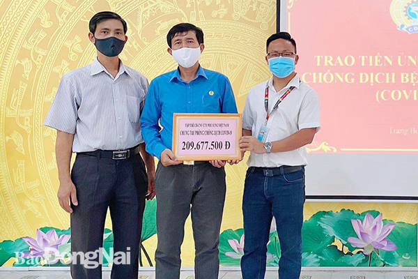 Đại diện Công đoàn cơ sở Công ty TNHH PouSung Việt Nam (H.Trảng Bom) trao số tiền ủng hộ của cán bộ, đoàn viên, người lao động cho Liên đoàn Lao động huyện.