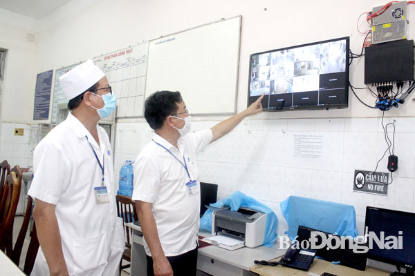 Phó giám đốc Sở Y tế Lê Quang Trung (phải) trao đổi với Giám đốc Bệnh viện Phổi Đồng Nai Nguyễn Ngọc Khánh về việc bố trí, lắp đặt camera tại khu vực điều trị cho bệnh nhân nhiễm Covid-19 tại bệnh viện. Ảnh: H.Dung
