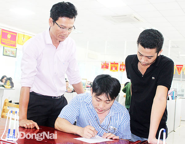 Đại diện Công đoàn cơ sở Công ty TNHH Pousung Việt Nam hỗ trợ công nhân làm thủ tục vay vốn, cải thiện đời sống. Ảnh: L.Mai