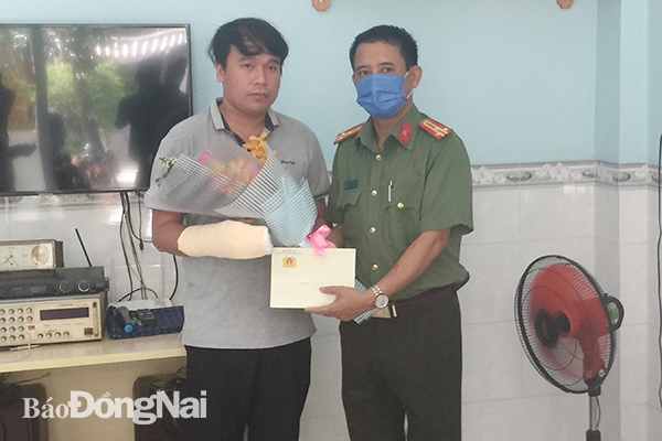 Thượng tá Nguyễn Văn Quảng, Phó trưởng phòng Xây dựng phong trào bảo vệ an ninh Tổ quốc  trao quà của Công an tỉnh cho anh Vũ Duy Đáng