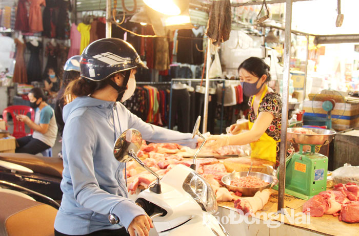 Người dân chọn mua sản phẩm thịt heo tại chợ Tân Hiệp (TP.Biên Hòa) Ảnh: HẢI QUÂN