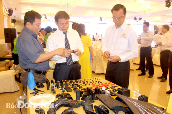 Giám đốc Công ty TNHH Tương lai Trương Quốc Cường (bìa trái) giới thiệu sản phẩm của doanh nghiệp với “ông vua ô tô” Trần Bá Dương (giữa)