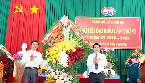 Phó bí thư thường trực Huyện ủy Long Thành Ngô Thế Ân (trái) tặng hoa chúc mừng Đại hội Đảng bộ xã Bình An