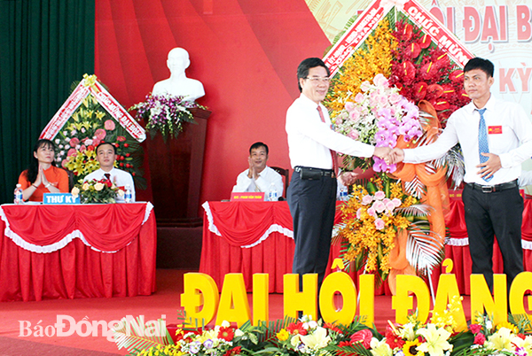 Bí thư Huyện ủy Long Thành Dương Minh Dũng (trái) tặng hoa  chúc mừng Đại hội Đảng bộ xã Long An