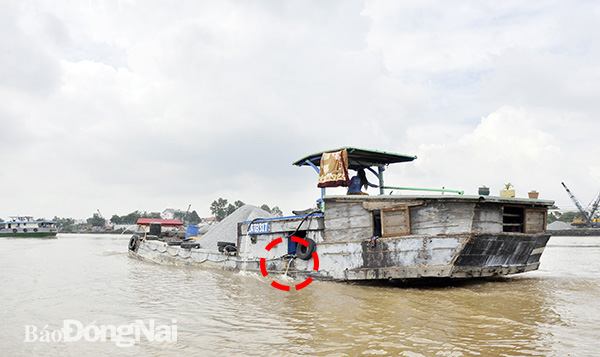 Ghe chở vật liệu xây dựng xả nước từ bộ phận làm mát khi lưu thông trên sông Đồng Nai qua TP.Biên Hòa. Ảnh: V.Nguyên