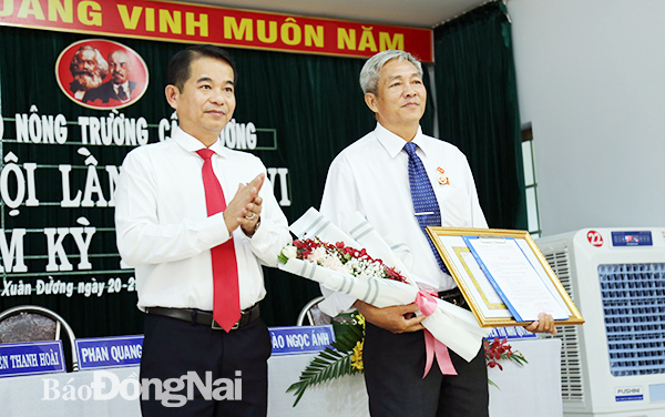 Đồng chí Thái Bảo, Trưởng ban Tuyên giáo Tỉnh ủy trao Huy hiệu 30 năm tuổi Đảng cho đồng chí Lê Hoàng Sang, một đảng viên của Nông trường Cẩm Đường