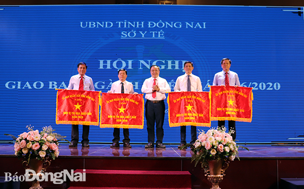 Giám đốc Sở Y tế Phan Huy Anh Vũ trao cờ thi đua cho các đơn vị
