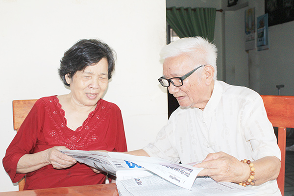 Ông Nguyễn Quang và bà Vũ Thị Tuyết Nhung đang đọc báo, cập nhật tình hình thời sự chuẩn bị cho nội dung sinh hoạt của CLB 19-5  Ảnh: N.Sơn