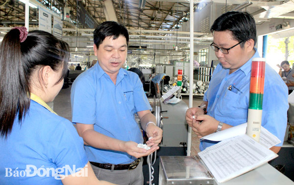 Anh Dương Phước Vinh (bìa phải), kỹ thuật viên Công ty TNHH Changshin Việt Nam - một trong 4 đại biểu của Đồng Nai được tuyên dương Người thợ trẻ giỏi - trong giờ làm việc. Ảnh: N.Tuyết