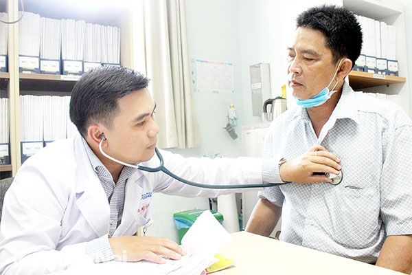 BS Nguyễn Tất Trung đang khám bệnh, tư vấn cho bệnh nhân. Ảnh: H.Dung
