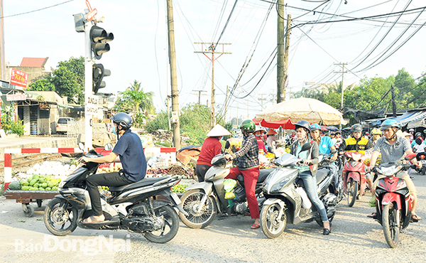 Tại km1684+780 thuộc xã Hố Nai 3 (H.Trảng Bom) người dân thường lấn chiếm làm nơi họp chợ, bày bán hàng hóa ngay cạnh đường sắt, cột đèn cảnh báo. Ảnh: T.Hải