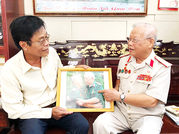 Thiếu tướng Nguyễn Ngọc Doanh xem lại những bức ảnh kỷ vật trong các chuyến tìm kiếm hài cốt liệt sĩ
