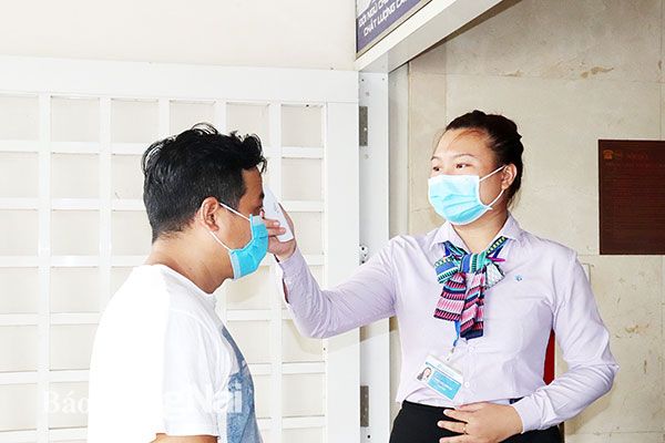 Nhân viên y tế kiểm tra thân nhiệt của tất cả những người vào Bệnh viện Đa khoa Đồng Nai ngày 1-8. Ảnh: Hạnh Dung