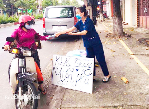 Một người dân ở TP.Biên Hòa phát khẩu trang y tế miễn phí cho người đi đường để phòng, chống dịch bệnh
