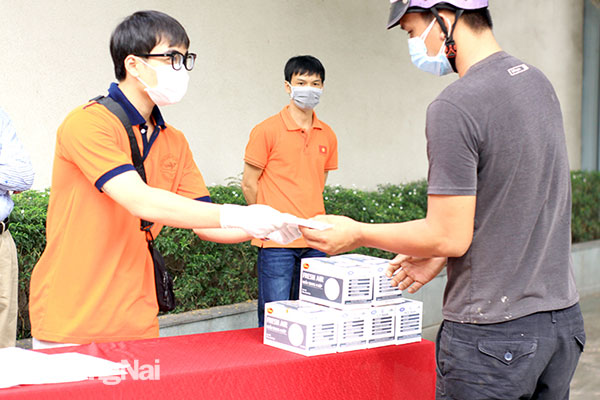 Sinh viên Trường đại học Lạc Hồng phát tặng khẩu trang cho người dân ở TP.Biên Hòa. Ảnh: H.An