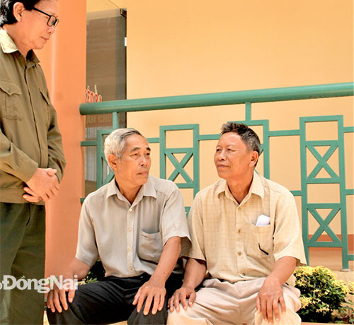 Ông Hoàng Ngọc Minh (phải), Chủ tịch Hội Nạn nhân chất độc da cam/dioxin xã Xuân Phú (H.Xuân Lộc) trò chuyện cùng một số người dân ở xã. Ảnh: V.Truyên
