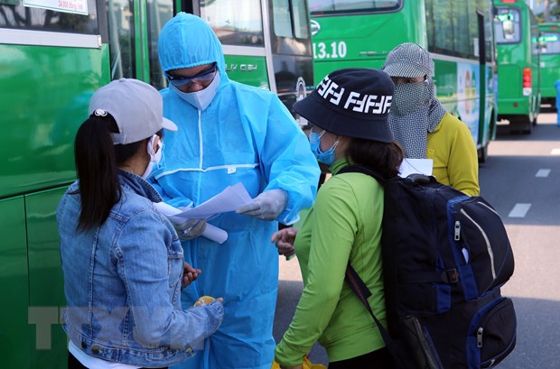 Hỗ trợ người dân khai báo y tế trước khi lên xe về Quảng Ngãi. (Ảnh: Trần Lê Lâm/TTXVN)