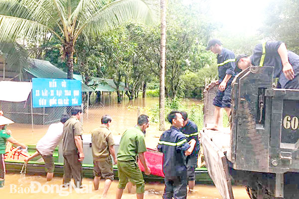 Lực lượng công an địa phương tham gia di dời tài sản của người dân xã Nam Cát Tiên (H.Tân Phú) trong đợt lũ lụt tháng 8-2019. Ảnh: Tố Tâm