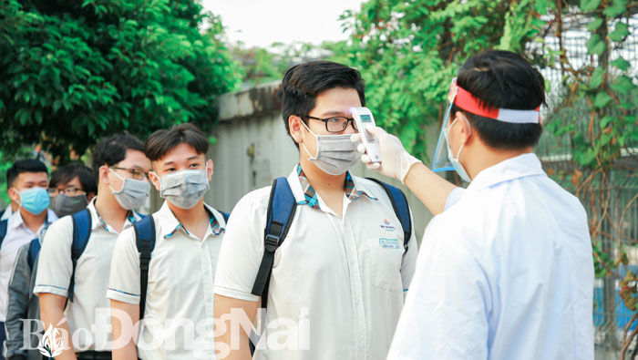 Trường THPT Lê Quý Đôn - Long Bình Tân (TP.Biên Hòa) thực hiện nghiêm việc đo thân nhiệt cho học sinh trước khi vào trường. Ảnh: H.Dung