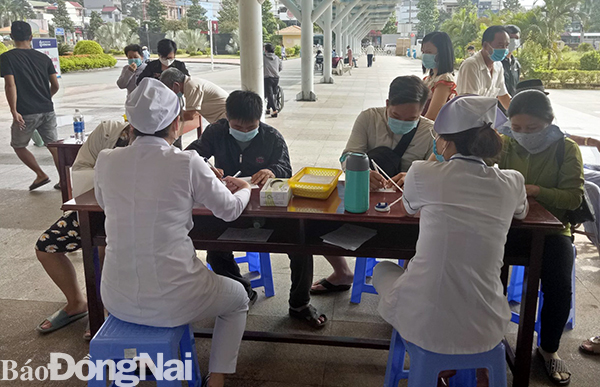 Người dân thực hiện khai báo y tế khi vào Bệnh viện Đa khoa Đồng Nai