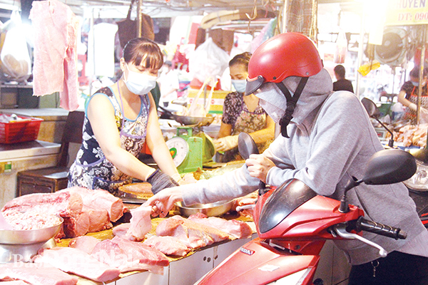 Người tiêu dùng chọn mua các sản phẩm thịt heo tại chợ Tân Hiệp (TP.Biên Hòa). Ảnh: Hải Quân