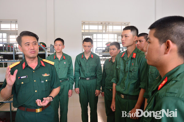 Thượng tá Nguyễn Tấn Linh (bìa trái) trao đổi với chiến sĩ huấn luyện tại Trung đoàn Đồng Nai. Ảnh: N.Hà
