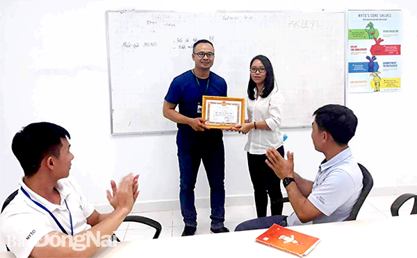 Chủ tịch Công đoàn cơ sở Nguyễn Văn Lương (trái) trao giấy khen của Liên đoàn Lao động TP.Long Khánh cho công nhân lao động giỏi tại công ty. Ảnh: T.Lâm