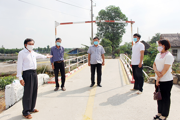 Lãnh đạo xã Phước Khánh (H.Nhơn Trạch) giới thiệu về cây cầu bê tông hóa thay cho cầu khỉ tại xã. Ảnh: N.HÀ