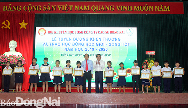 Đại diện lãnh đạo Tổng công ty Cao su Đồng Nai trao thưởng cho các em học sinh