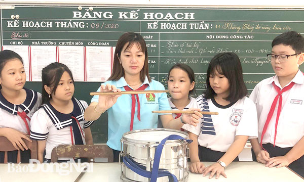 Cô giáo Trần Thị Thanh Tuyền hướng dẫn đội viên thiếu nhi cách đánh trống Đội. Ảnh: Nga Sơn