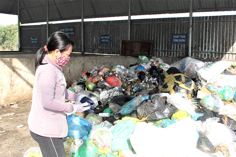 Người dân xã Tân Bình, H.Vĩnh Cửu phân loại rác tại điểm tập kết rác sinh hoạt của xã. Ảnh: Ban Mai