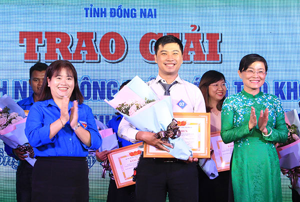 Đồng chí Bùi Thị Bích Thủy (bìa phải) và đồng chí Nguyễn Thanh Hiền (bìa trái), Phó bí thư phụ trách Tỉnh đoàn tặng bằng khen và hoa cho thí sinh đoạt giải nhất cuộc thi 