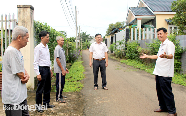 Ông Nguyễn Bá Ngọc (bìa phải) giới thiệu với lãnh đạo huyện và xã tuyến đường nông thôn mới nâng cao sáng - xanh - sạch - đẹp tại ấp. Ảnh: N.Hà