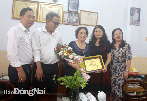 Đại diện NXB Đồng Nai trao biểu trưng tri ân cho gia đình cố nhà văn Hoàng Văn Bổn. Ảnh Ly Na