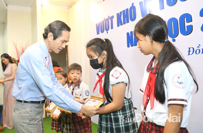 Đồng chí Nguyễn Tất Độ, Phó chủ tịch UBMTTQ tỉnh trao học bổng cho các em học sinh