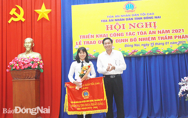 Phó chủ tịch UBND tỉnh Võ Văn Phi trao cờ thi đua xuất sắc 5 năm liền của TAND tối cao cho TAND H.Long Thành. Ảnh: T. Tâm