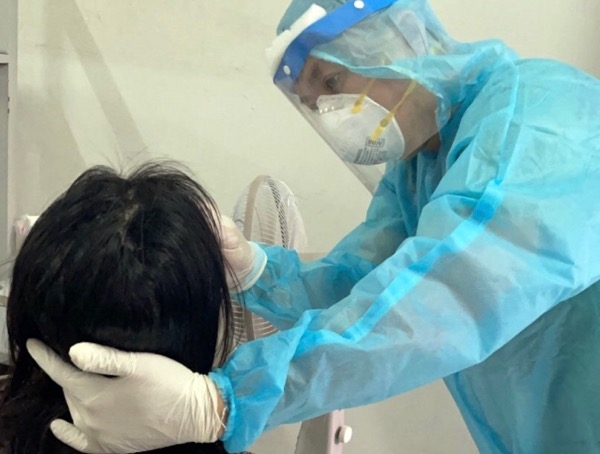 Nhân viên y tế của Trung tâm Y tế TP.Biên Hòa lấy mẫu xét nghiệm SARS-CoV-2 cho người cách ly tại khu cách ly Trường cao đẳng Y tế Đồng Nai.