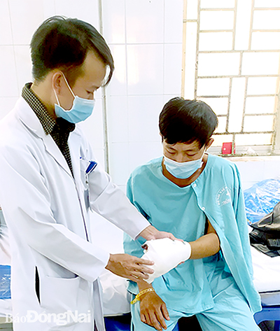 Bác sĩ thăm khám vết thương bàn tay cho bệnh nhân sau ca phẫu thuật