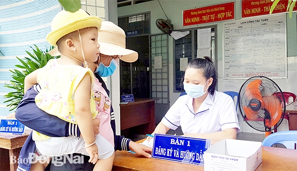 Trạm Y tế P.Trảng Dài (TP.Biên Hòa) ngưng khám chữa bệnh bảo hiểm y tế.  Trong ảnh: Người dân đưa trẻ đến Trạm Y tế phường để tiêm chủng.  Ảnh: Hoàn Lê