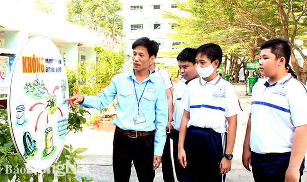 Anh Thăng Văn Thắng, giáo viên Tổng phụ trách Đội Trường THCS Võ Trường Toản (H.Vĩnh Cửu) tuyên truyền về cách phòng, chống dịch bệnh sốt xuất huyết cho học sinh. Ảnh: Nga Sơn