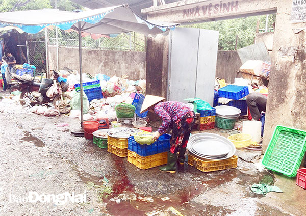 Một sạp hàng bán cá gần bãi rác và trước cửa nhà vệ sinh ở chợ Tam Hòa (TP.Biên Hòa) không đảm bảo an toàn vệ sinh thực phẩm. Ảnh: Phương Liễu