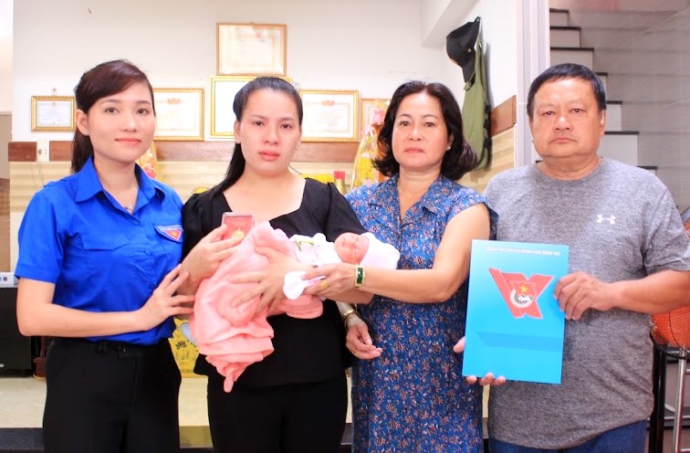 Chị Hồ Hồng Nguyên trao Huy hiệu Tuổi trẻ dũng cảm cho đại diện gia đình anh Quang (Ảnh: Tỉnh đoàn cung cấp)