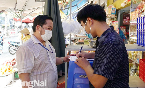 Đoàn kiểm tra liên ngành lập biên bản vi phạm hành chính đối với người dân không đeo khẩu trang tại chợ Biên Hòa vào sáng ngày 6-5