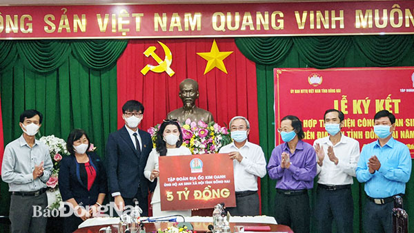 Đại diện Quỹ từ thiện Kim Oanh trao bảng tượng trưng số tiền 5 tỷ đồng thực hiện các hoạt động an sinh xã hội tại Đồng Nai. Ảnh: Nguyệt Hà