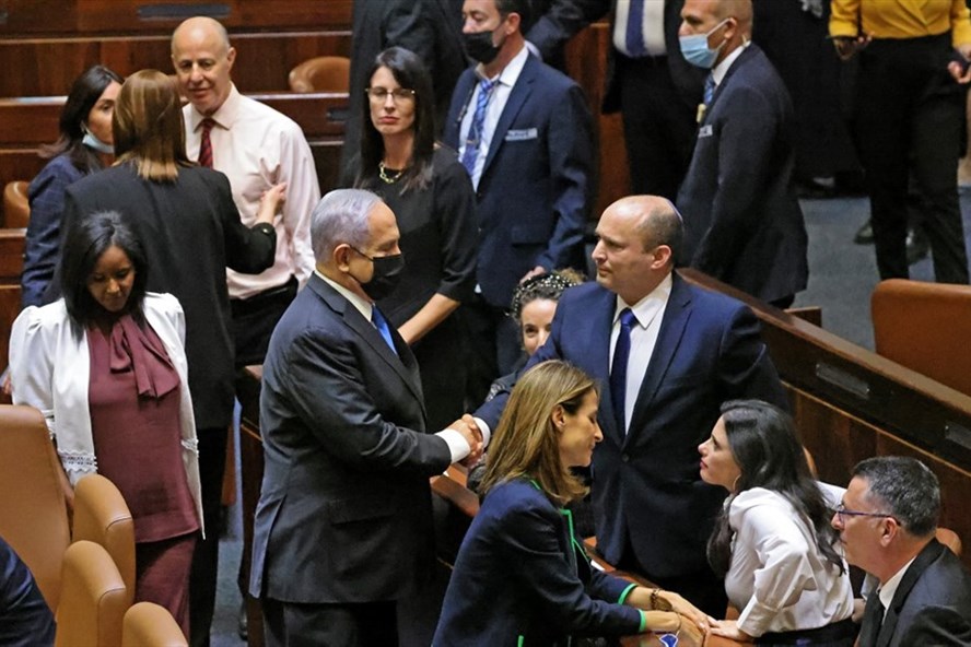 Thủ tướng Israel Benjamin Netanyahu bắt tay người kế nhiệm Naftali Bennett sau một phiên họp đặc biệt để bỏ phiếu về chính phủ mới tại Knesset ngày 13.6. Ảnh: AFP