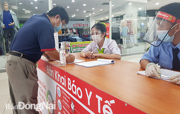Khách hàng khai báo y tế trước khi vào siêu thị BigC Đồng Nai mua sắm. 